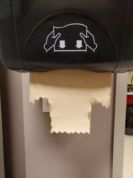 a black trash can with a paper roll sticking out of it