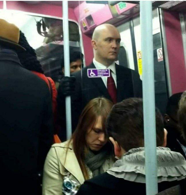 a man in a suit and tie is on a subway train