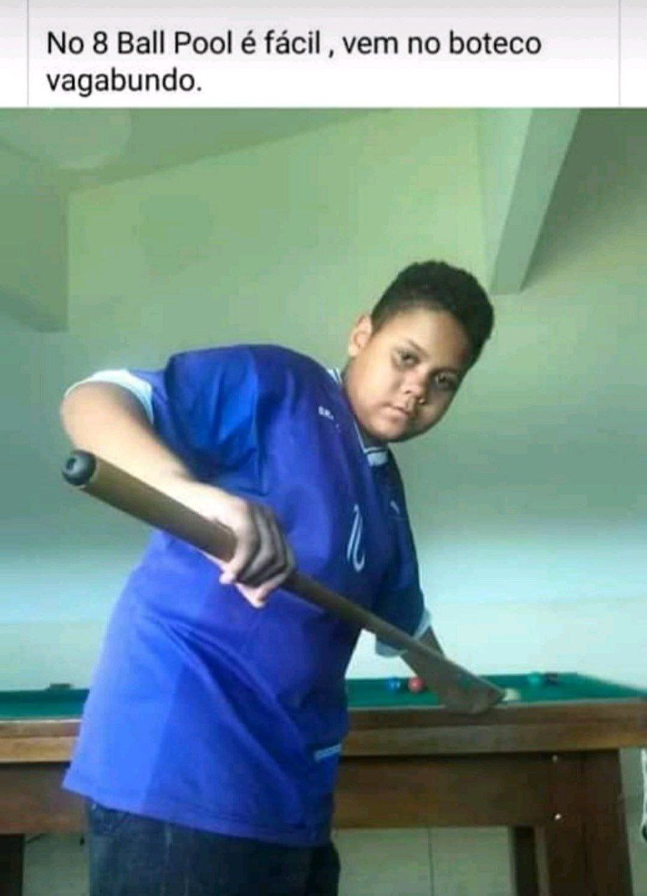 a man in a blue shirt is playing pool