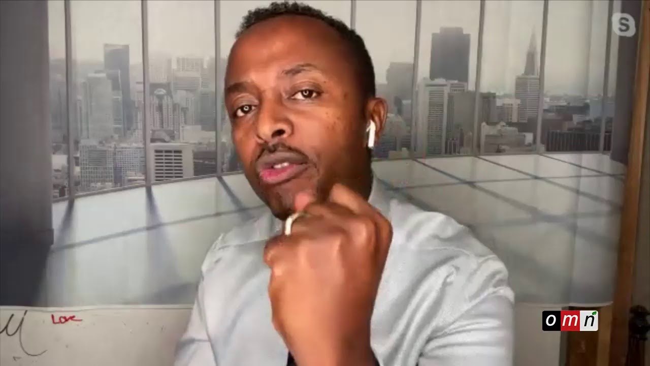 a man in a white shirt is sitting down