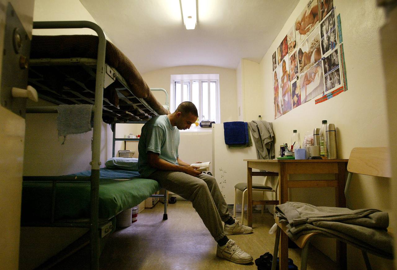 a man sitting on a bunk bed in a room