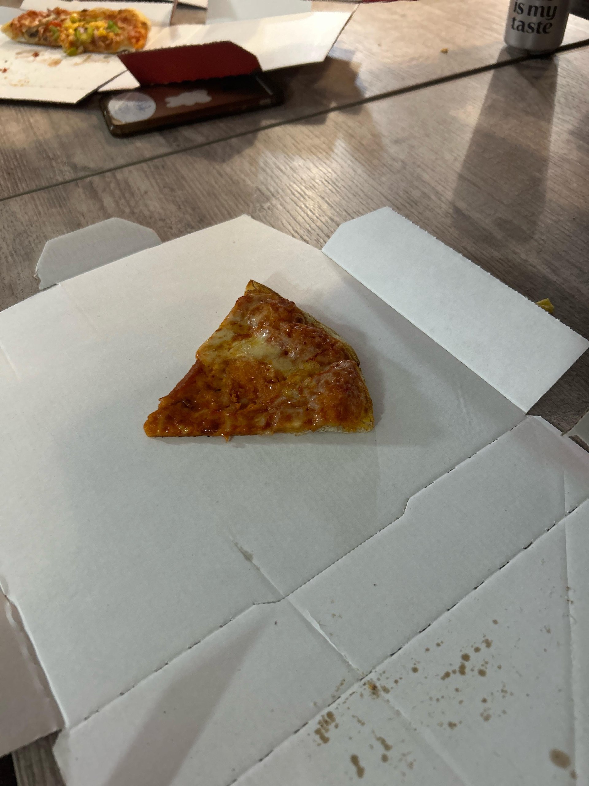 a slice of pizza on a table with a cup of coffee