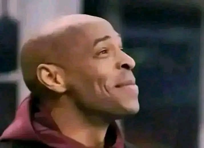 a man in a red jacket is standing in front of a building